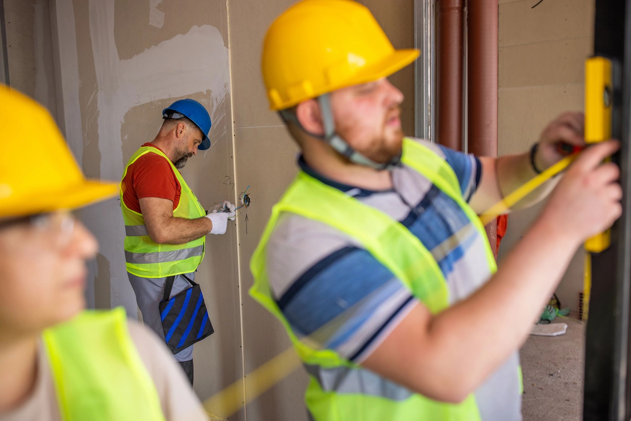Construction workers measuring and aligning a window pane
