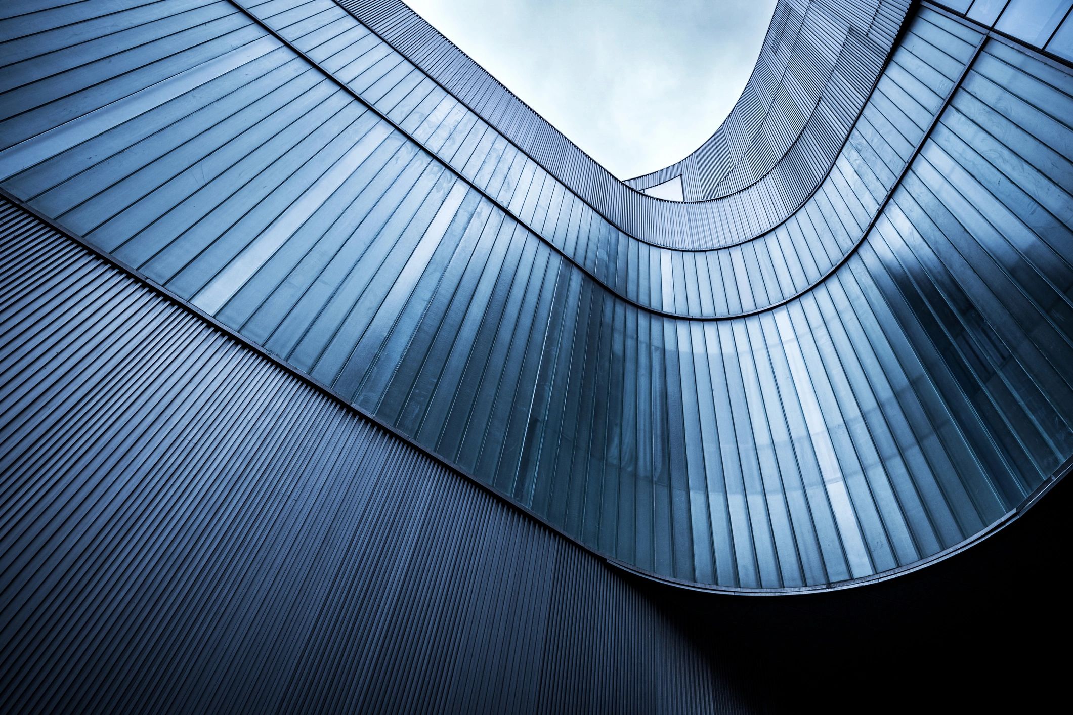 Curved blue-tinted glass facade with modern lines