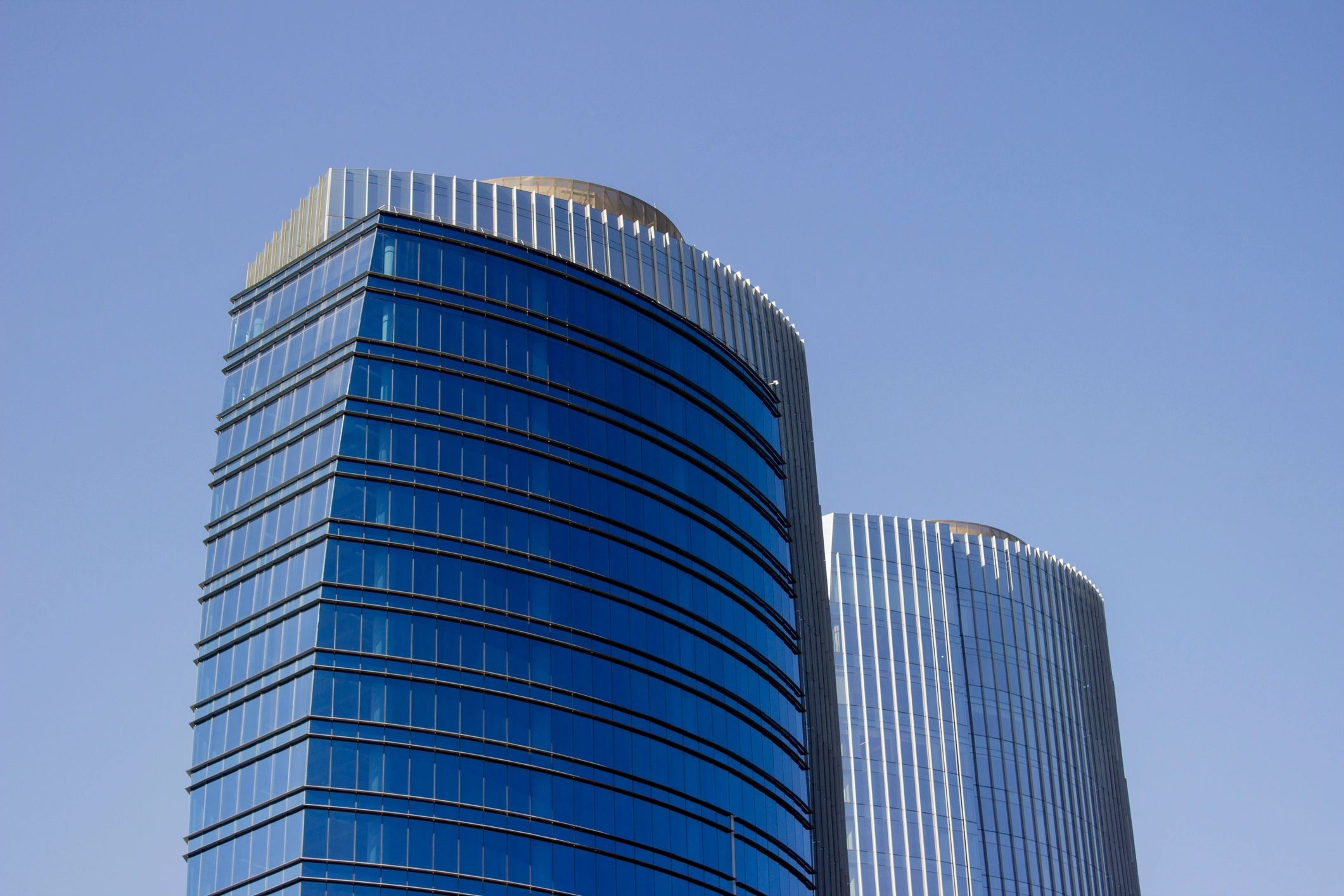 Blue glass high-rise facade viewed from below